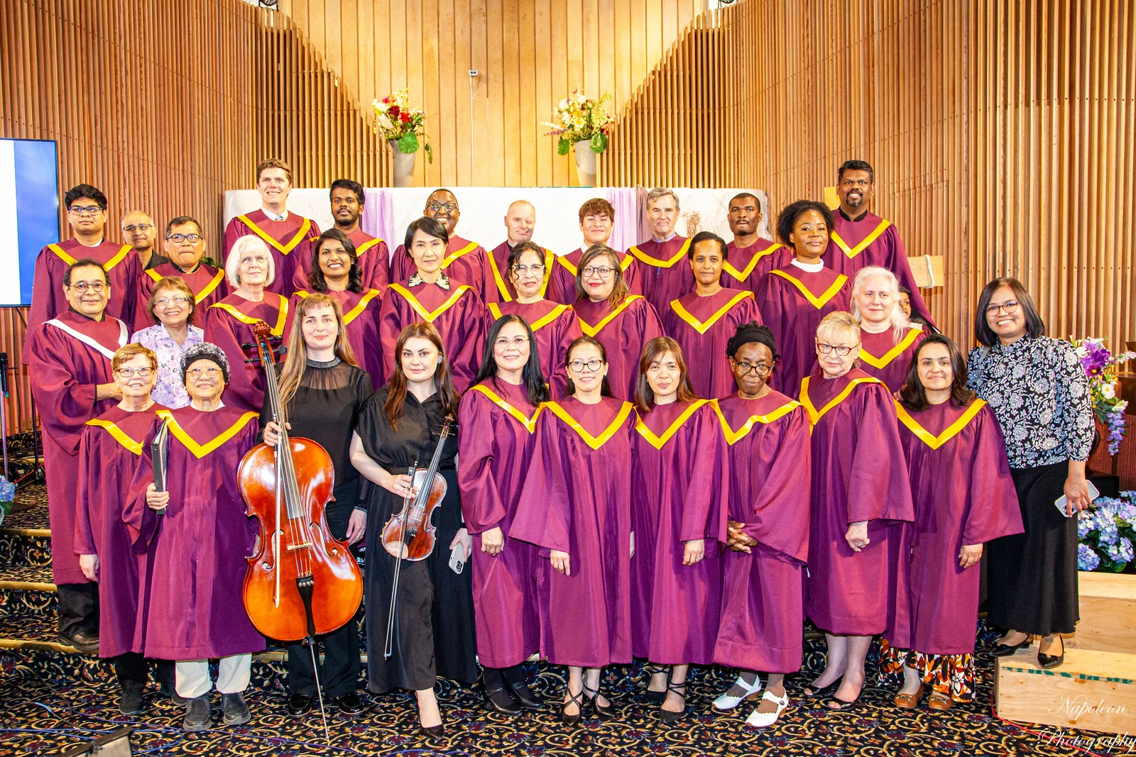 The Edmonton Central choir in maroon and gold robes with a cellist and a violinist in the sanctuary